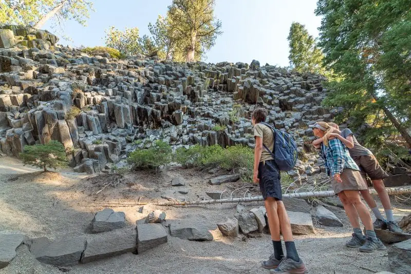 Family looks at the columns of the Devil's Post Pile in Devils Postpile National Monument in California