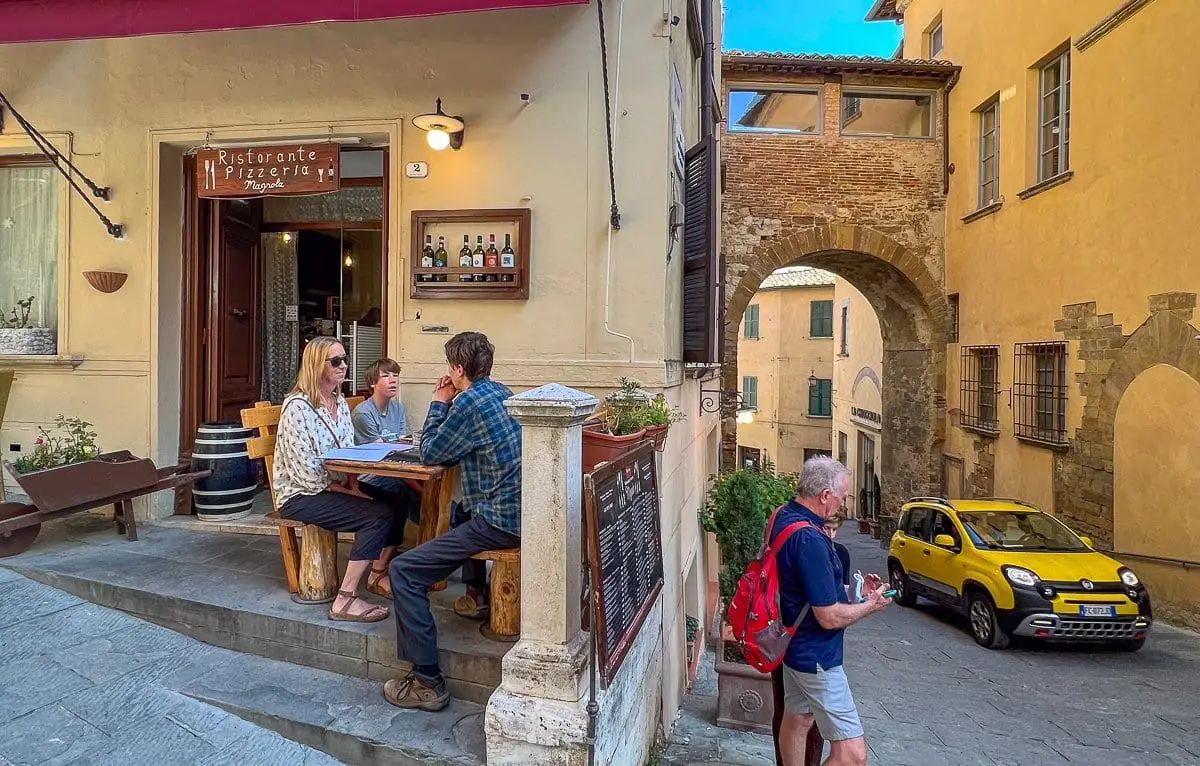 Family sits at table in small restaurant in Montepulciano, Tuscany