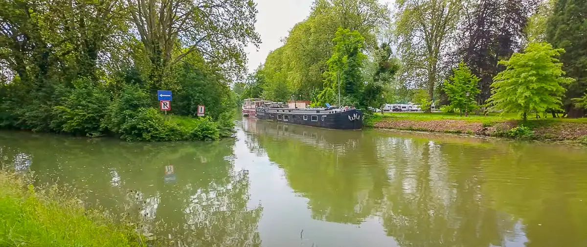 Canal boat on a tree lined canal in Dole, France during our citywalk