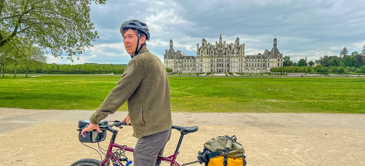 Bicycle Tour rider in front of Chambord Chateau in spring before virtual walking tour of Orleans