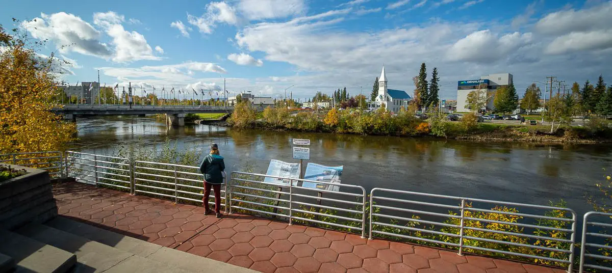 Woman looks over Chena River from Golden Hearts Plaza that we see during our Fairbanks virtual walk